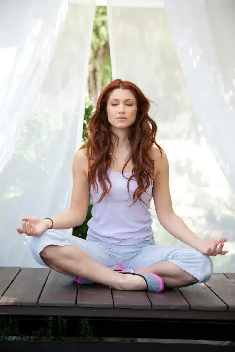 Femme méditant en tailleur dans une posture de yoga